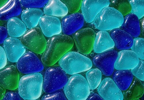 Abstract pattern of wet polished turquoise, sapphire, and emerald glass pebbles. photo