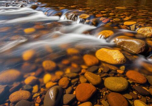 Abstract long exposure of fast flowing clear river water cascading over smooth amber stones photo