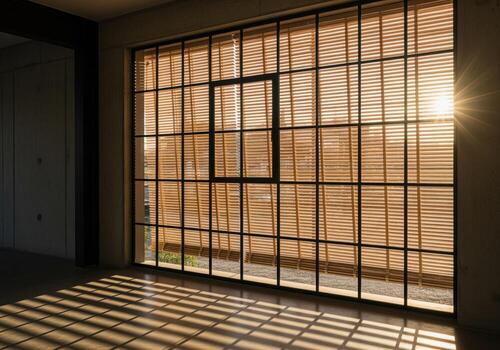 Dramatic sunlight filtering through bamboo venetian blinds on a large architectural window. photo