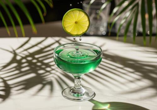 Dynamic splash of green cocktail as a fresh lime slice drops into a coupe glass photo