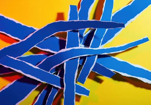 Vibrant abstract composition of torn blue paper strips overlapping on a bright yellow background. photo