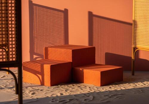 Warm terracotta product display stands on sandy floor with geometric rattan shadows photo