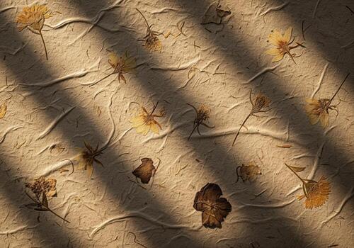 Natural textured paper with embedded dried flowers and dramatic sunlight shadow pattern. photo