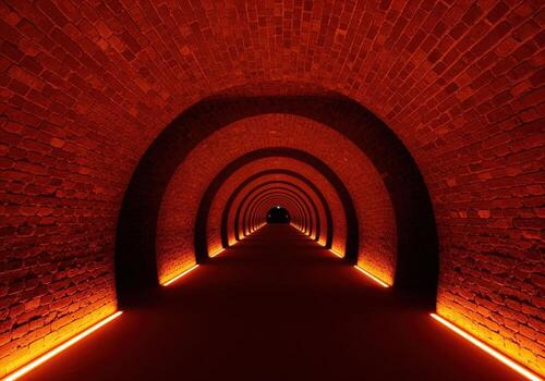 Deep perspective of a red brick arched tunnel illuminated by warm orange neon light photo