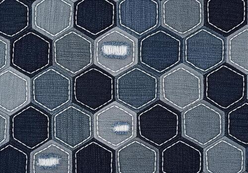 Distressed indigo denim fabric texture pattern with quilted hexagonal patches and stitching. photo