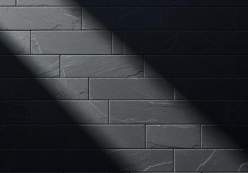 Dark charcoal gray slate tile wall texture background with dramatic diagonal shadow photo