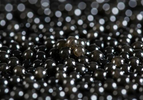 Close up view of glistening black caviar texture with abstract bokeh lights photo