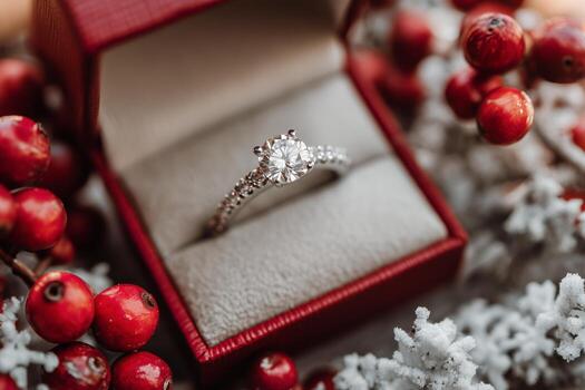 Elegant Diamond Ring Displayed in a Red Box Surrounded by Festive Decorative Berries photo