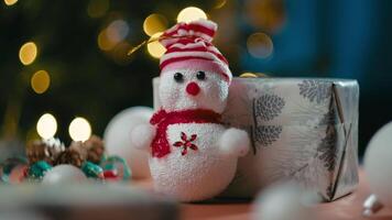 jul marionett på en tabell i främre av de träd och presenterar video