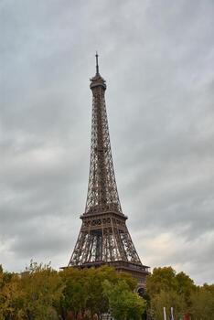 The Eiffel Tower in Paris, built in 1889 as an emblem of the World's Fair, seen from its base on a cloudy day photo
