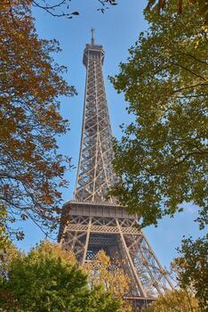 Eiffel Tower in Paris, seen from a narrow street with classical architecture and autumn trees as a legacy of the World's Fair photo