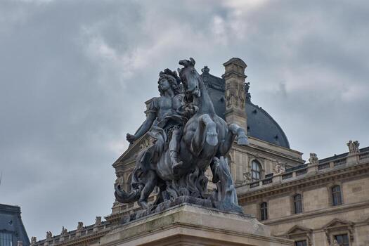 Equestrian statue of Louis XIV in the courtyard of the Louvre Museum in Paris with a cloudy sky and classical architecture in the background photo