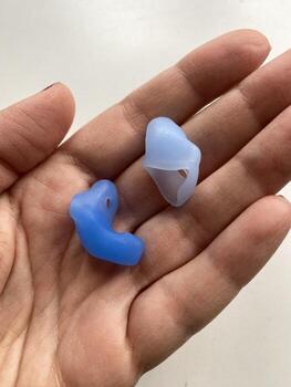 Custom silicone earplugs resting on an open palm, providing noise protection and comfort photo
