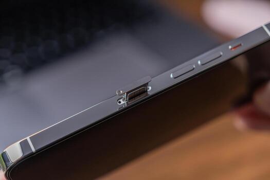 Detail of a sleek smartphone with its SIM card tray partially ejected, symbolizing essential mobile connectivity, telecommunication, and modern data technology photo