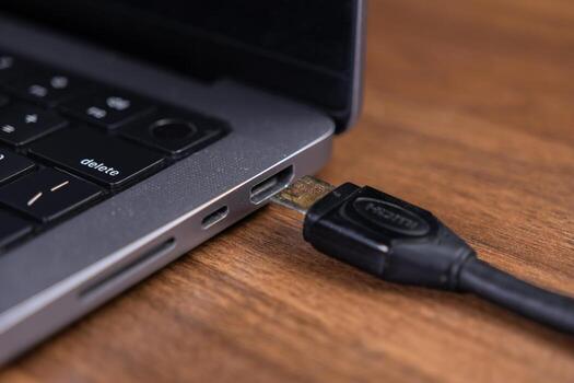 Close-up view of an HDMI cable connected to a laptop's port, highlighting seamless digital connectivity and efficient data transfer for display integration photo
