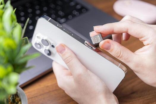 Person installing new micro SIM card into modern white smartphone, enabling essential mobile connectivity, network activation, and digital communication technology access photo