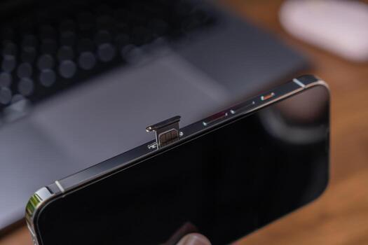 Sleek smartphone featuring an ejected SIM card tray, highlighting essential mobile connectivity, network setup, and modern telecommunication technology for users photo