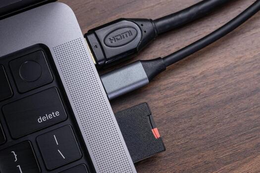 Sleek laptop featuring HDMI cable and memory card reader connections, representing essential digital device connectivity and efficient data transfer solutions photo