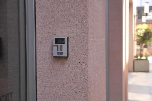 Modern intercom system installed on a smooth concrete wall photo
