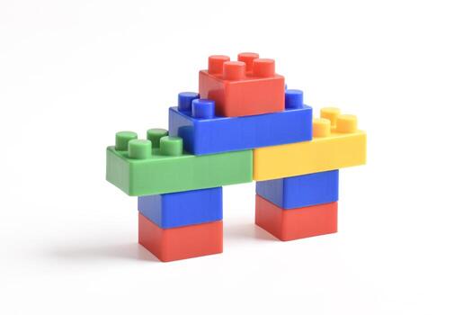 Colorful building blocks stacked to form a playful structure on a white background. photo