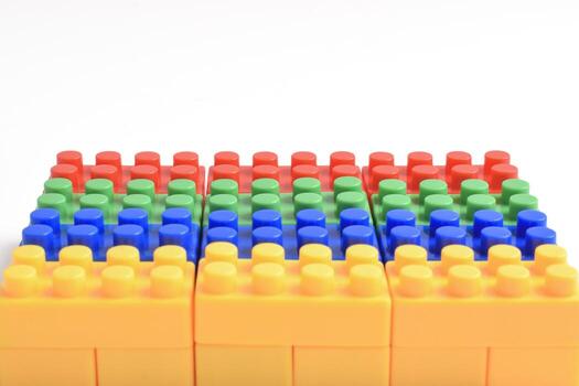 Rows of colorful interlocking building blocks arranged in a grid pattern on a white background. photo