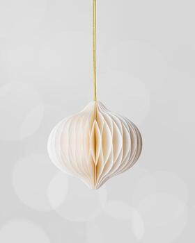 Minimal Christmas ornament, white paper New Year ball as flashlight hanging on golden string, on grey blurred bokeh background. Winter holiday decoration trends, light neutral colored, vertical card. photo