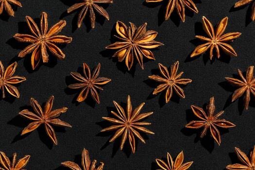 Anise stars background food pattern, top view close up photography fragrant spices dry anise seeds on black background, natural organic seasoning texture, dark colored minimal flat lay photo