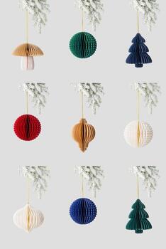 Minimal style set photo of colorful paper Christmas ornaments of different shapes hanging on white snow fir branch on neutral background Concept of holiday decoration, eco design, festive aesthetics.