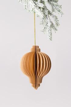 Minimal Christmas ball as flashlight from craft brown paper hanging on golden string on snow white pine tree branch on grey background. Festive Winter holidays xmas decor, minimal design, side view. photo