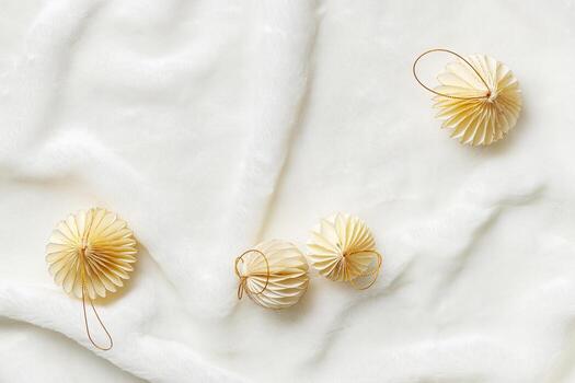 New Year Festive winter holidays concept, Minimal style top view aesthetic layout with cream beige paper ornaments, Christmas balls on white fluffy fur background, flat lay modern pattern photo