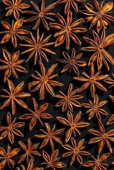 Anise stars background food pattern, top view close up photography fragrant spices dry anise seeds on black background, natural organic seasoning texture, dark colored minimal flatlay photo