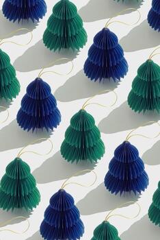 Top view of green blue honeycomb paper Christmas ornaments in minimal trend pattern on light background. New Year fir tree with sun shadow creating rhythmic, graphic layout modern holiday themes. photo