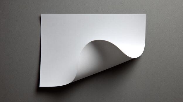 White paper sheet with curled corner on gray background photo