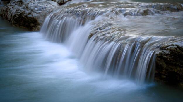 Flowing waterfall over rocks in natural environment photo