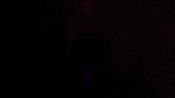 un' sbalorditivo astratto rappresentazione di un' nero buco nel in profondità spazio. minuscolo rosso particelle e polvere nuvole orbita e siamo consumato di il potente gravitazionale Tirare video