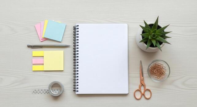Office desk with notepad, pens, scissors, and plant photo