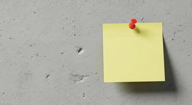 Yellow sticky note pinned to a wall with red push pin photo