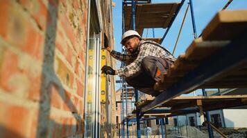 konstruktion arbetstagare använder sig av anda nivå montera fönster ram video