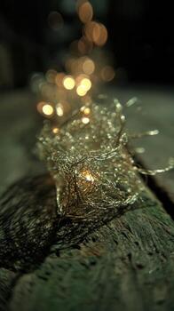 Close-up view of glowing tree garland lights against a wooden surface creating a dreamy atmosphere in the evening photo