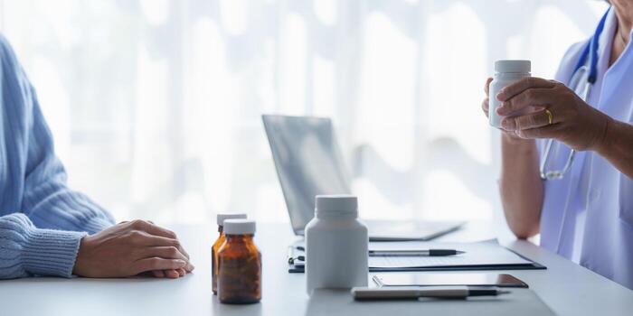 Doctor having conversation with patient while discussing explaining symptom and hold hand for encourage photo