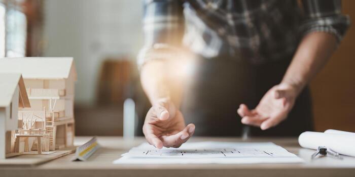 Architecture drawing something while working with blueprint in the office. Architecture and Engineer concept photo