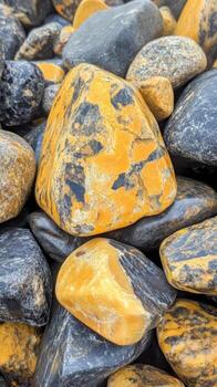 Beautiful array of unique black and yellow stones found along a rocky shoreline. photo