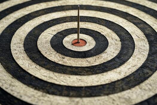 Dart with heart-shaped tip hits center of target on a bullseye in a calm setting. photo