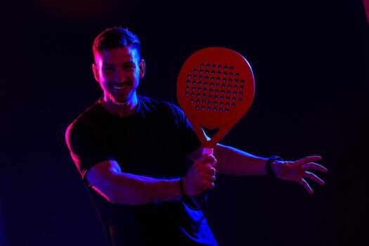 Man enjoying a game with a large paddle in a colorful, dynamic setting photo