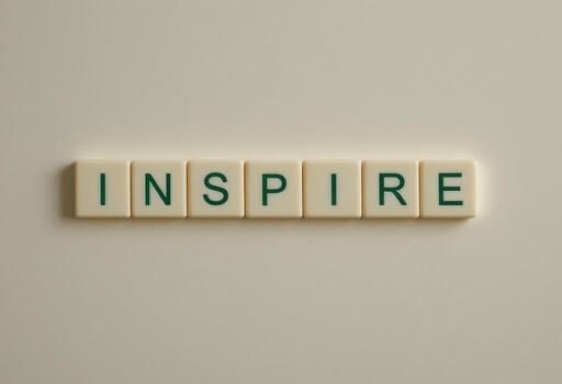 Inspire Word Made with Alphabet Tiles on Neutral Background photo