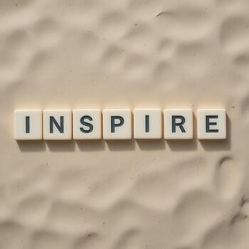 Inspire Motivational Message in letter tiles Letters on Sandy Background photo