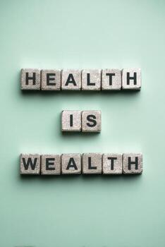 Health is Wealth Concept with Letter Blocks on Soft Green Background photo