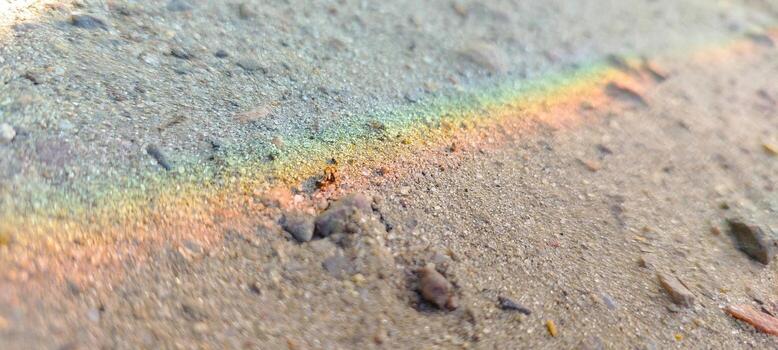 Rainbow Reflecting on Wet Sand After a Light Rain at the Beach During Late Afternoon photo