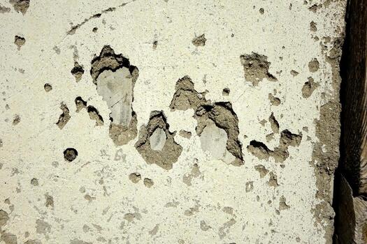 Detailed View of a Textured Plaster Wall With Weathered Patches and Exposed Layers in Natural Light photo