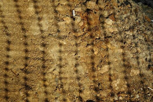 Shadow on the ground from a road repair net with cigarette butts from builders photo
